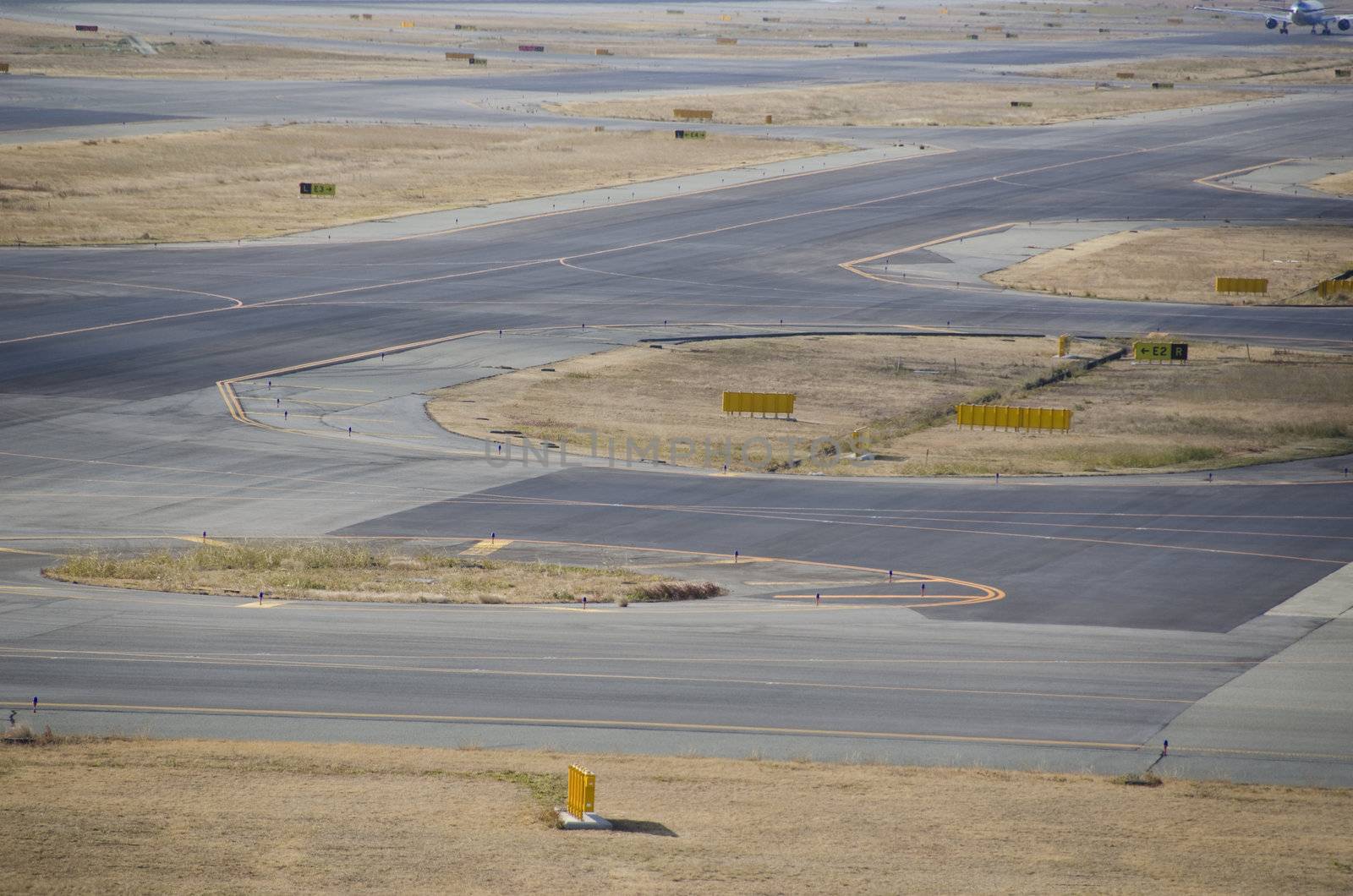 Detail of a runway at a airport with asphalt and grass