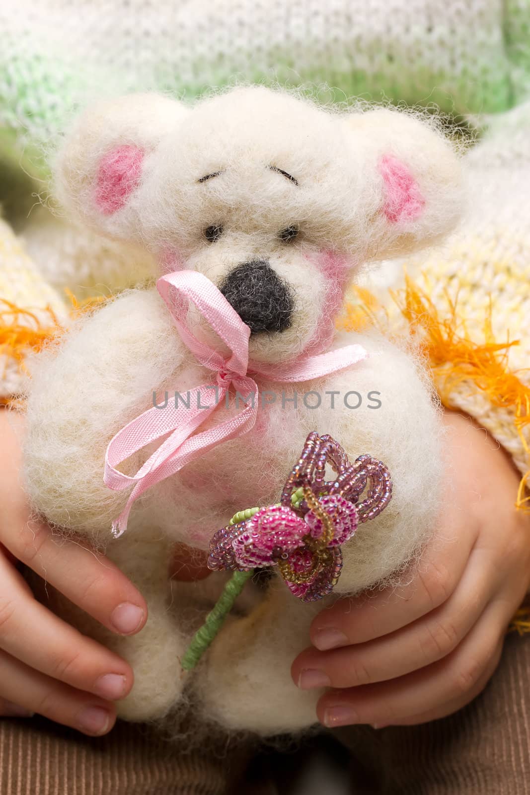 Handmade teddy bear close-up in the hands of a child