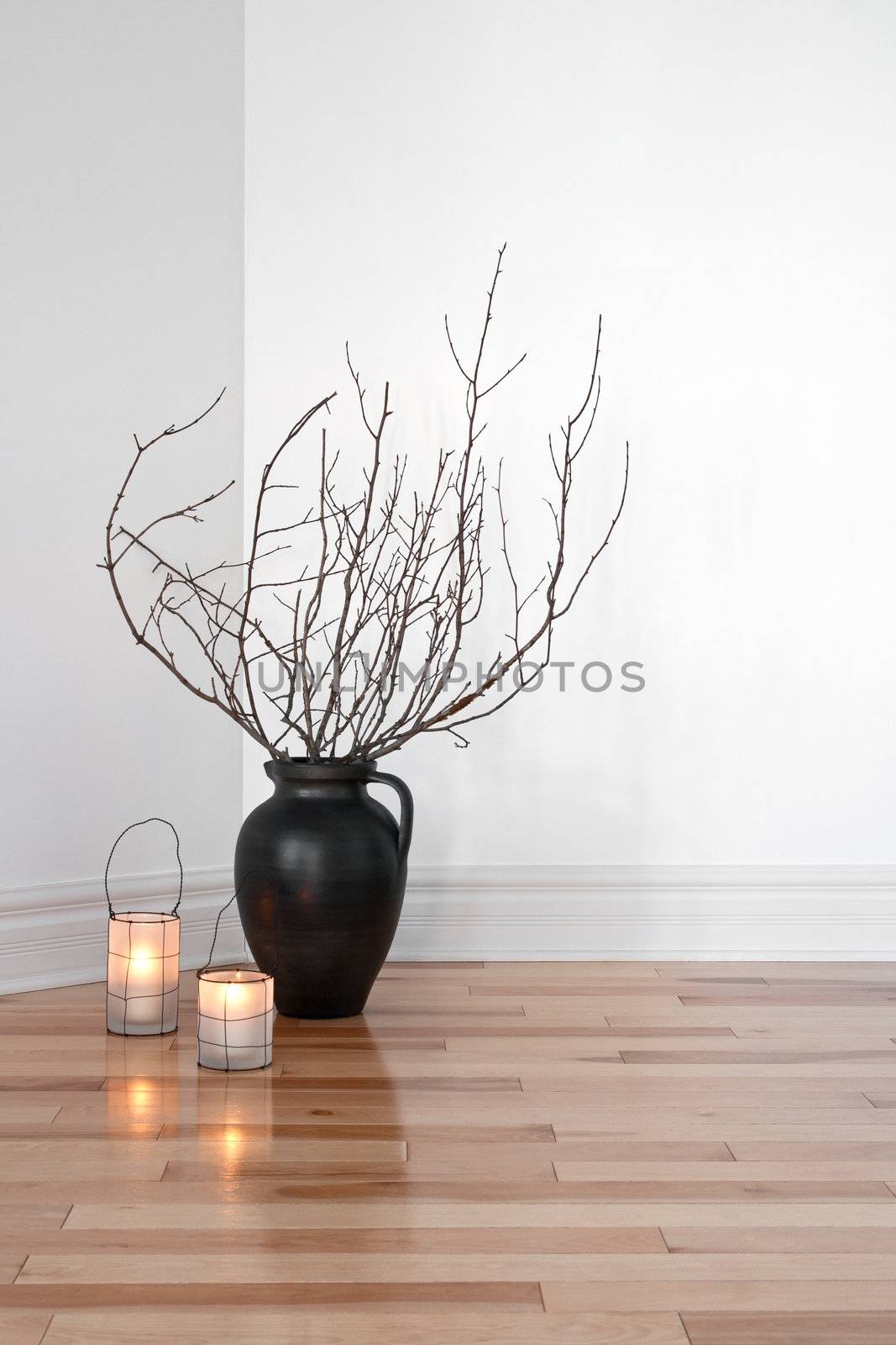 Cozy lanterns and tree branches in a vase, decorating a room.