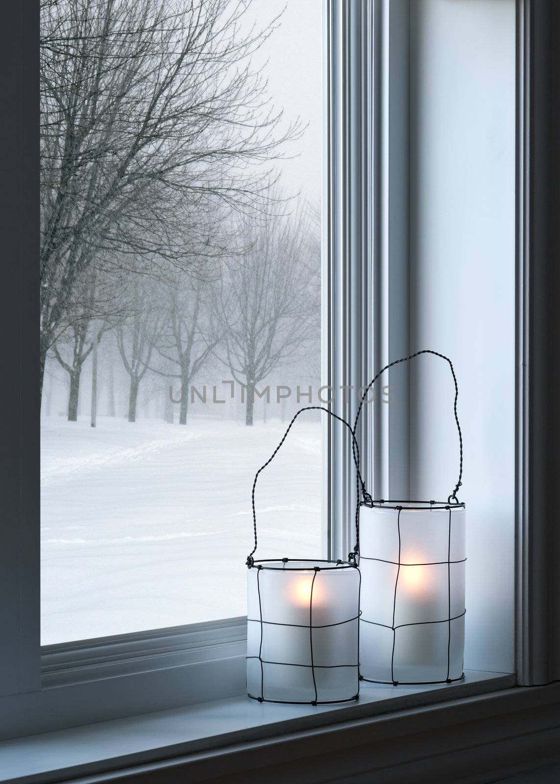 Cozy lanterns on a windowsill, with winter landscape seen through the window.