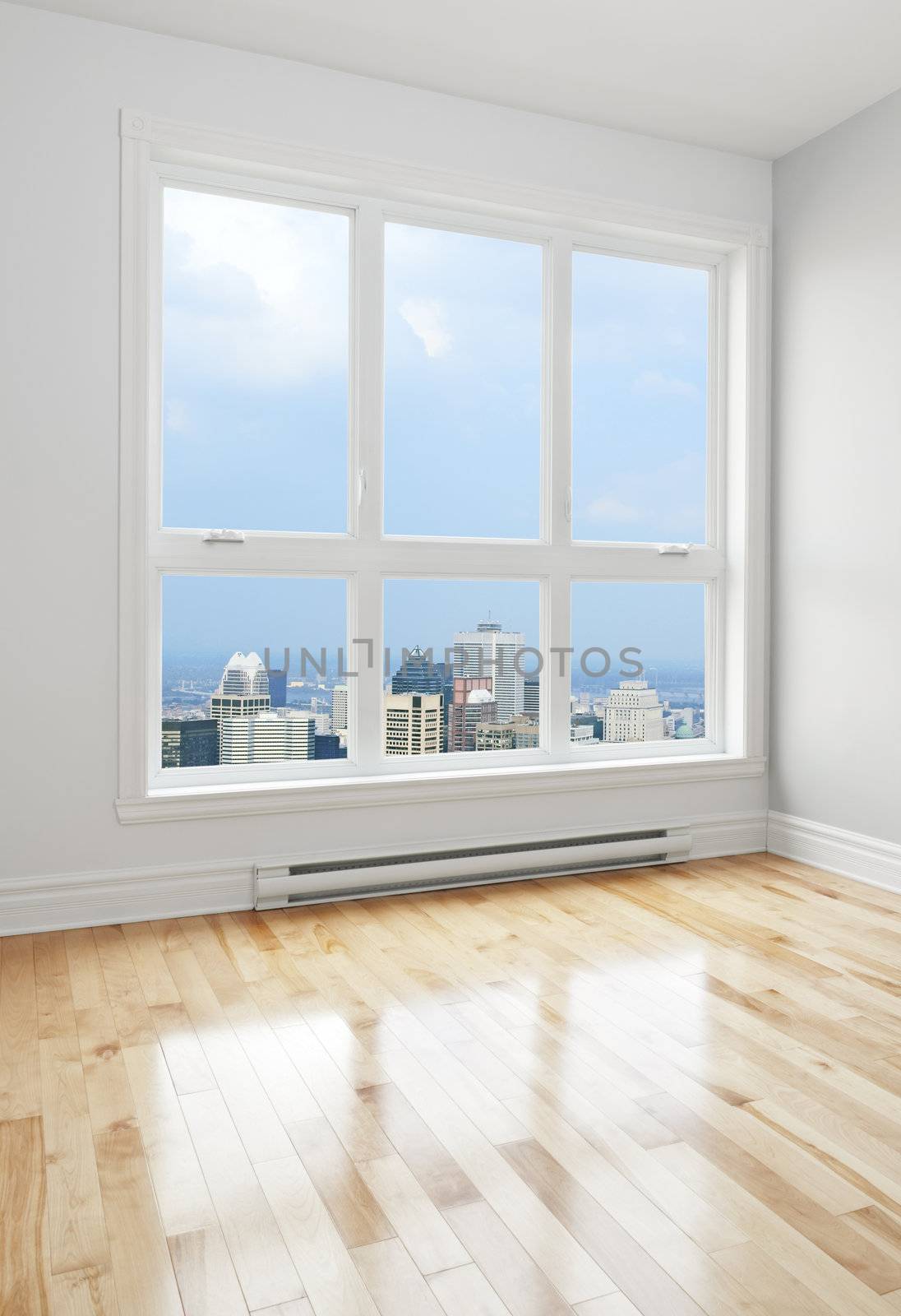 City skyscrapers seen through the big window of an empty room.