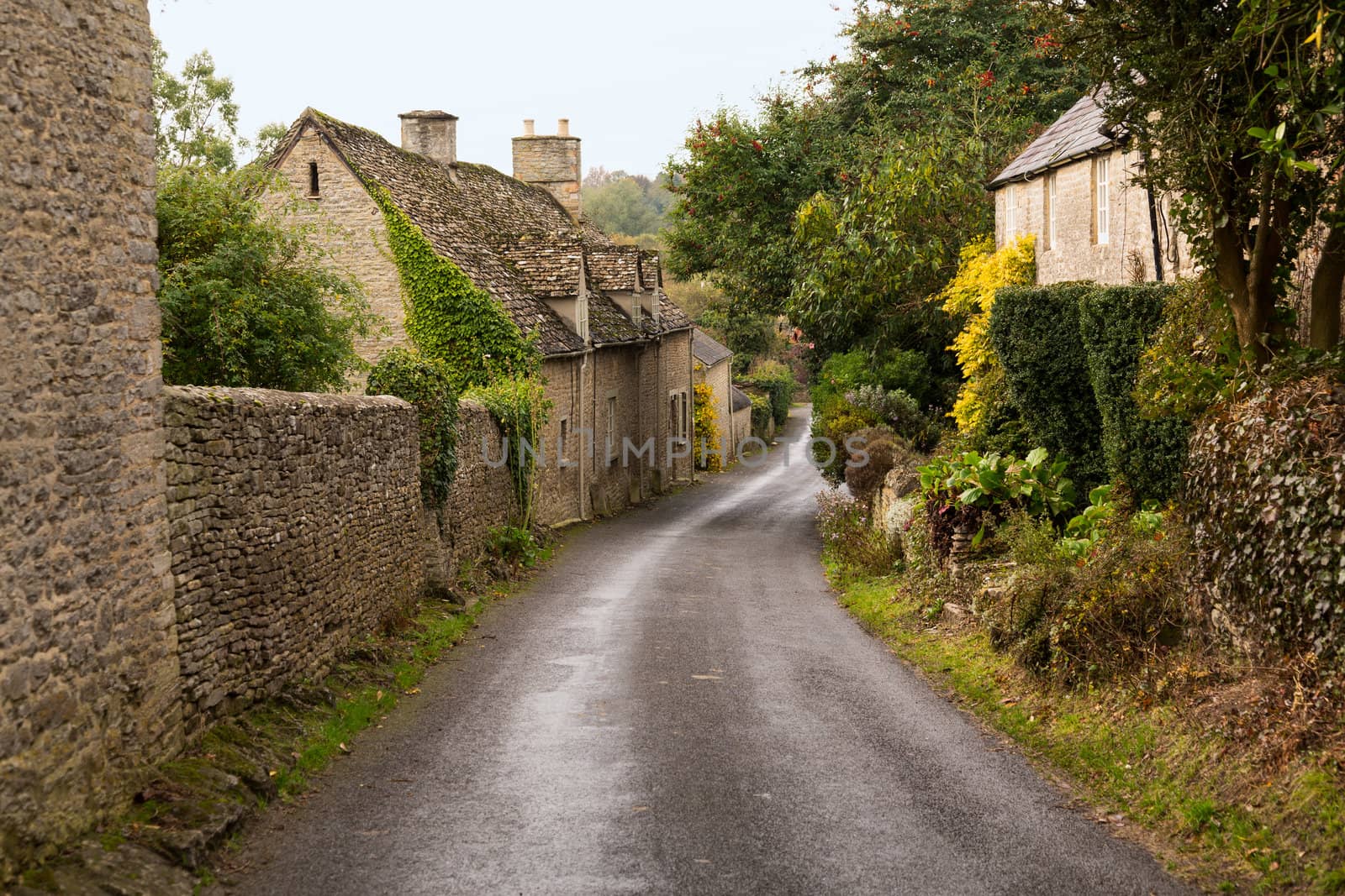 Narrow lane in vilalge of Minster Lovell in Cotswolds with stone cottages