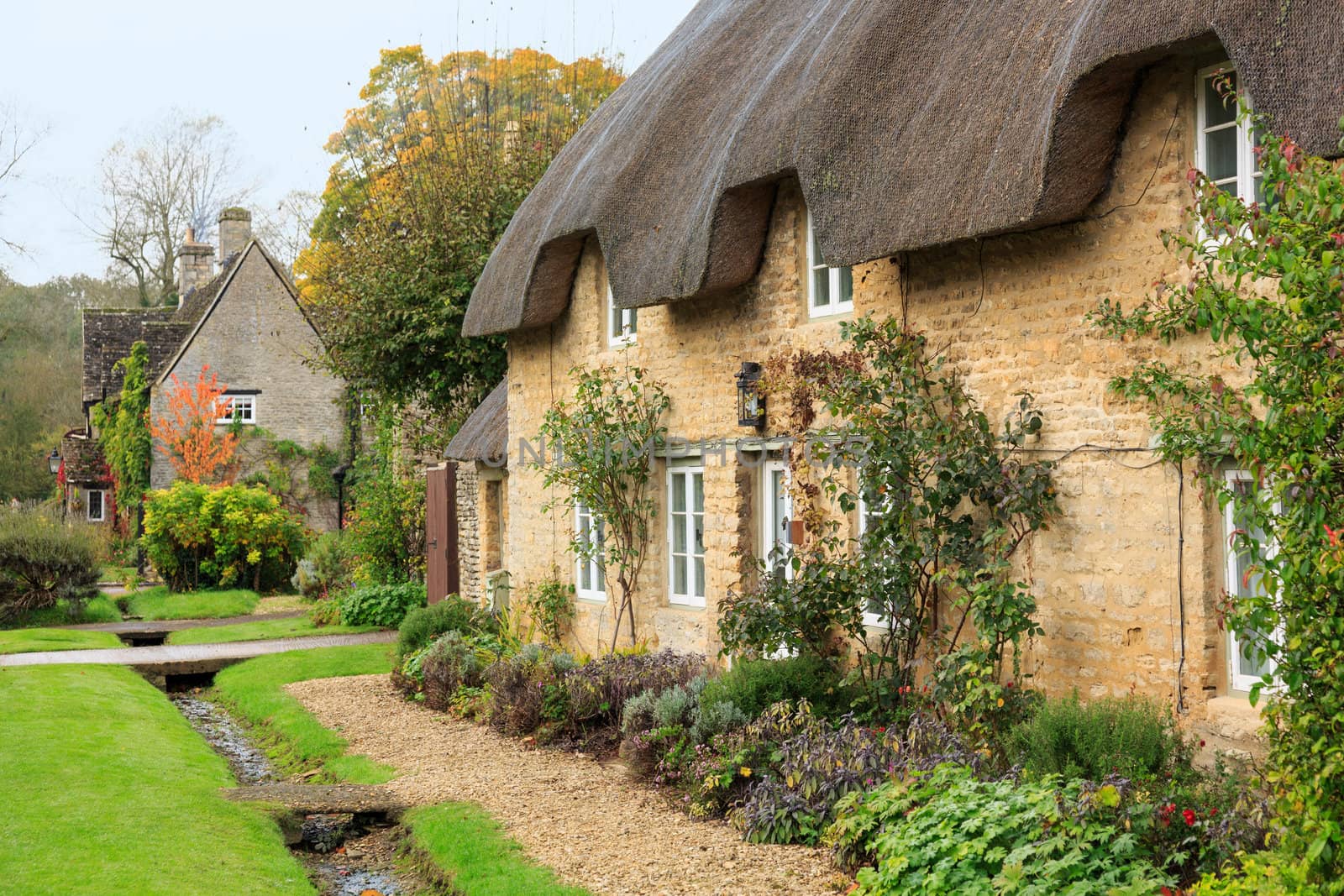 Narrow lane in vilalge of Minster Lovell in Cotswolds with stone cottages