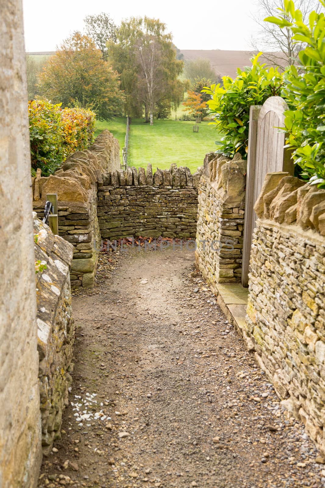 Narrow footpath between stone walls from Swinbrook to Widford in Windrush Valley
