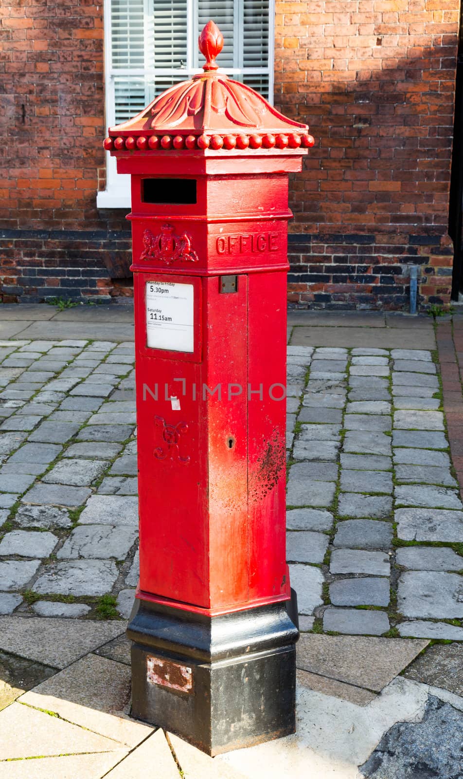 Traditional red pillar box style post box created for Queen Victoria