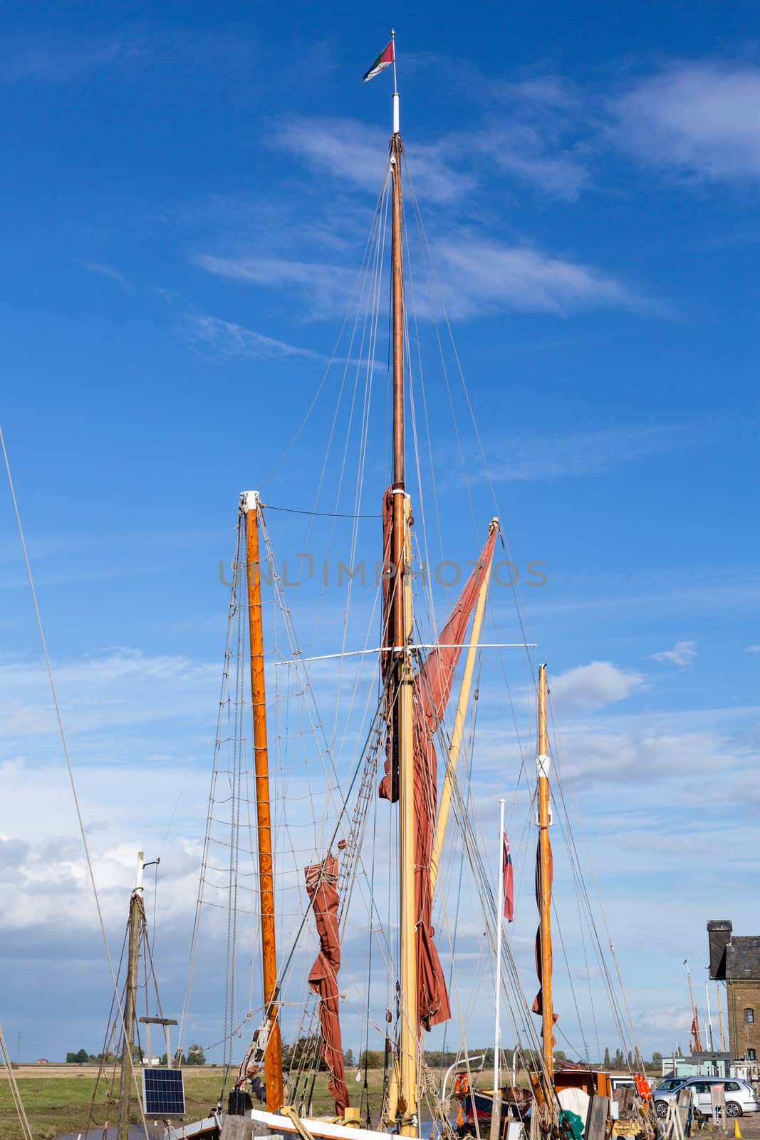 Thames sailing ship or barge with masts and sails by dock in Faversham Kent UK