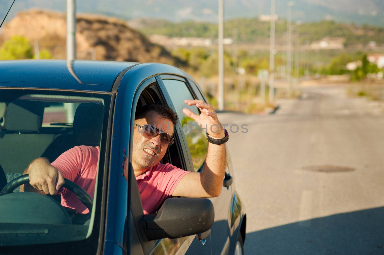 Guy gesturing out of the window of his car