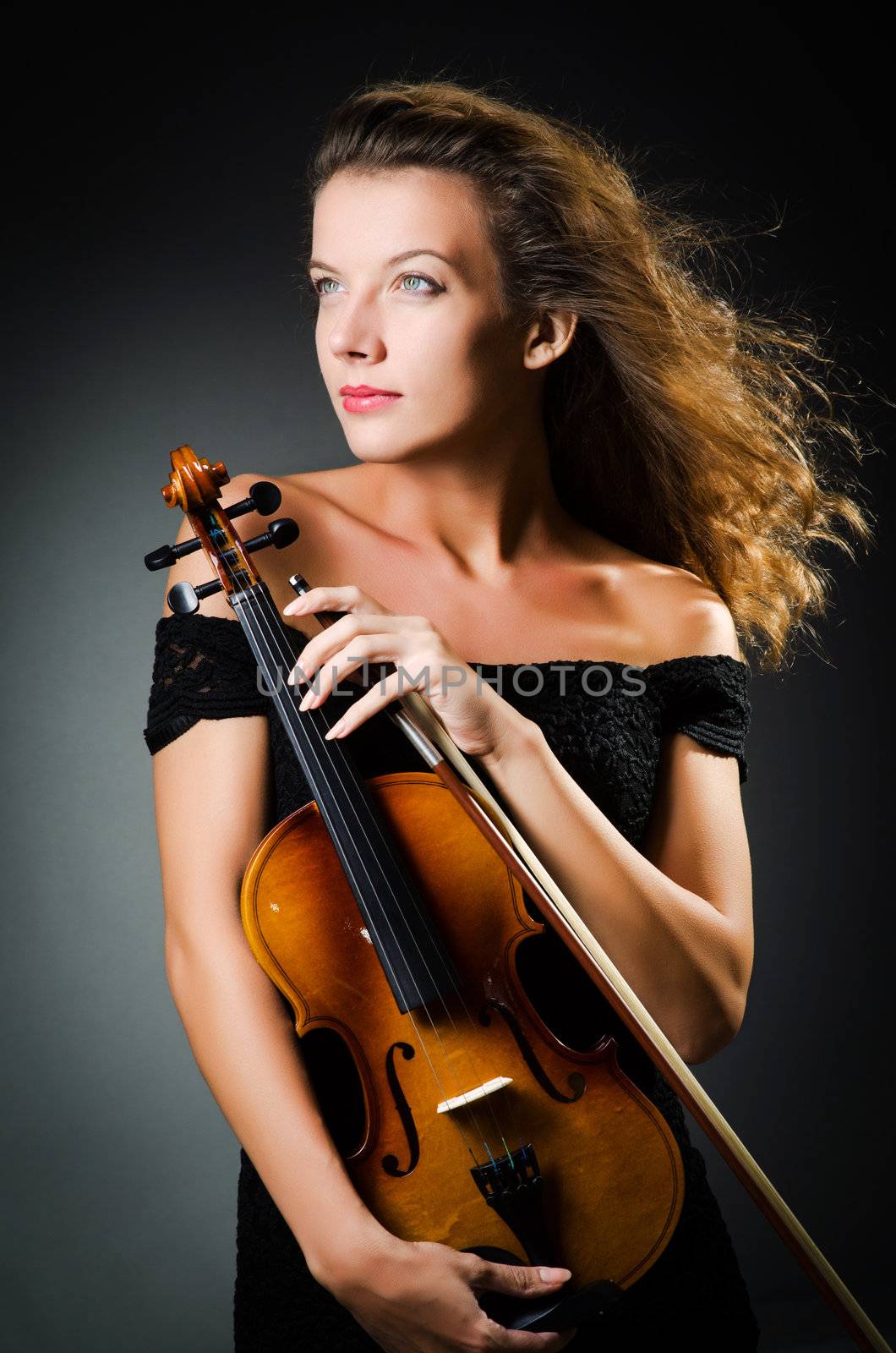 Woman with violin in dark room