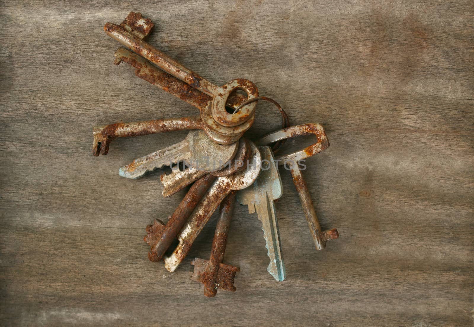 Old and rusty ring of keys on wood