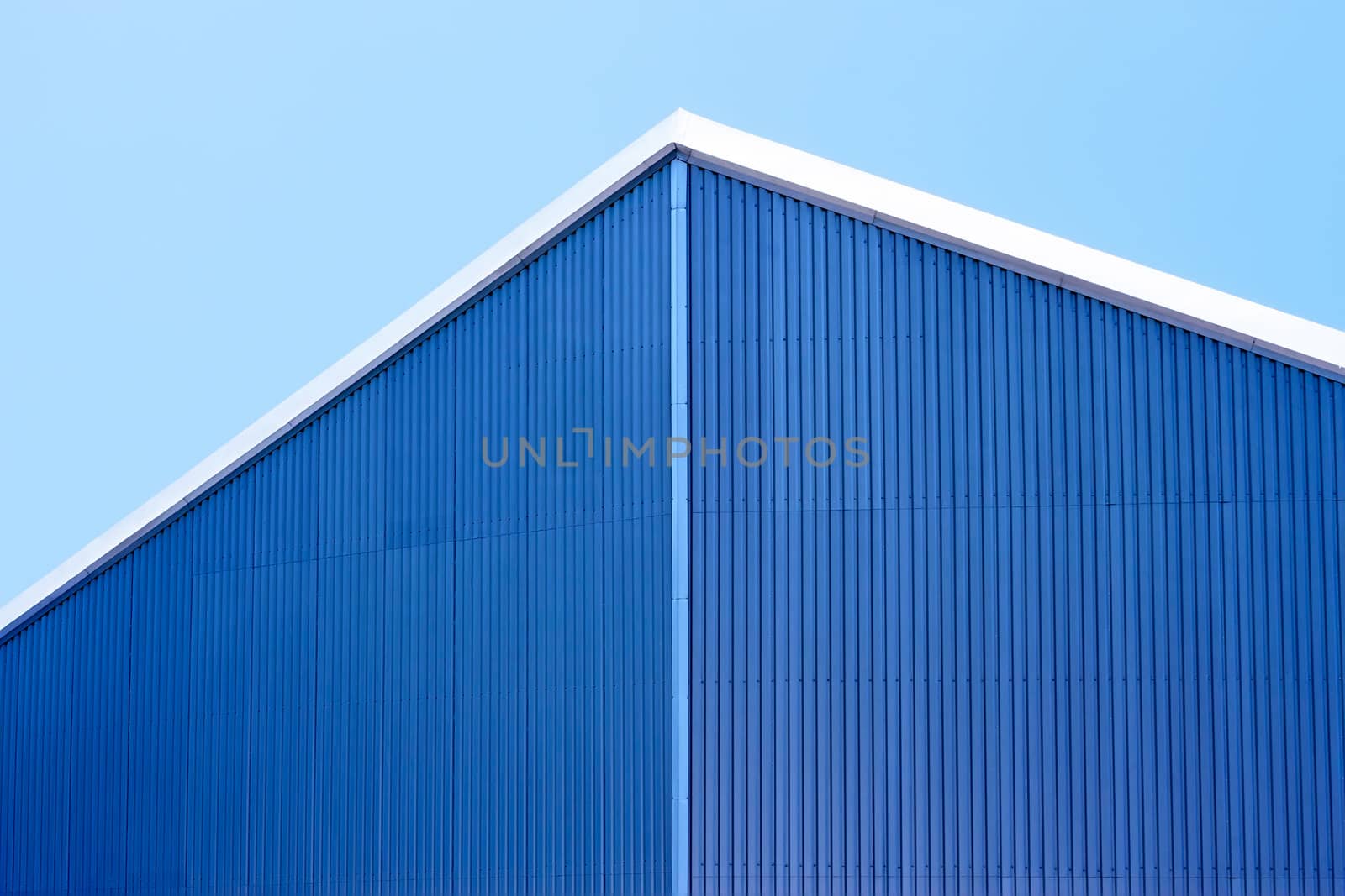 Detail the roof of parallel sheets of metal against a blue sky