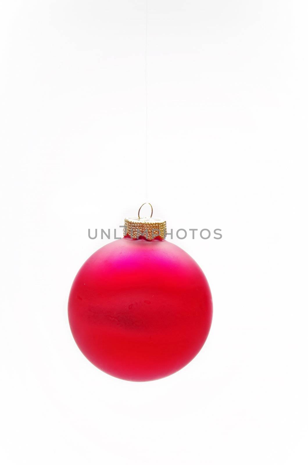 Red Christmas bauble, hanging from a wire, isolated on a white background.