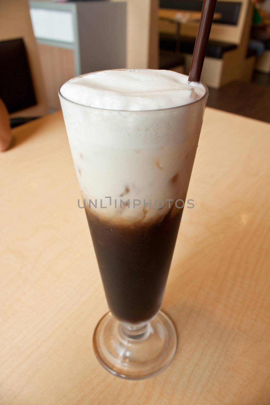 Ice coffee in the glass on the wood table