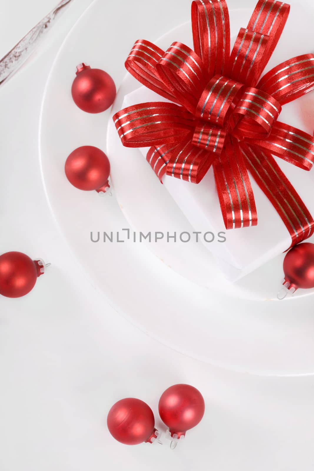 White present with red ribbons on a dinner plate, christmas them by jarenwicklund