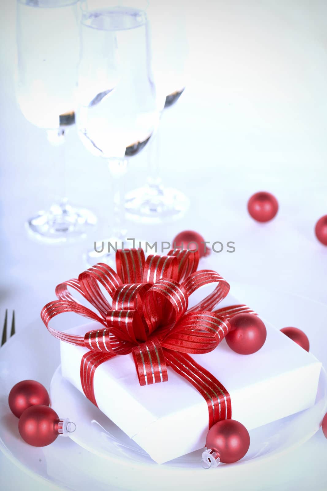 White present with red ribbons on a dinner plate, christmas theme