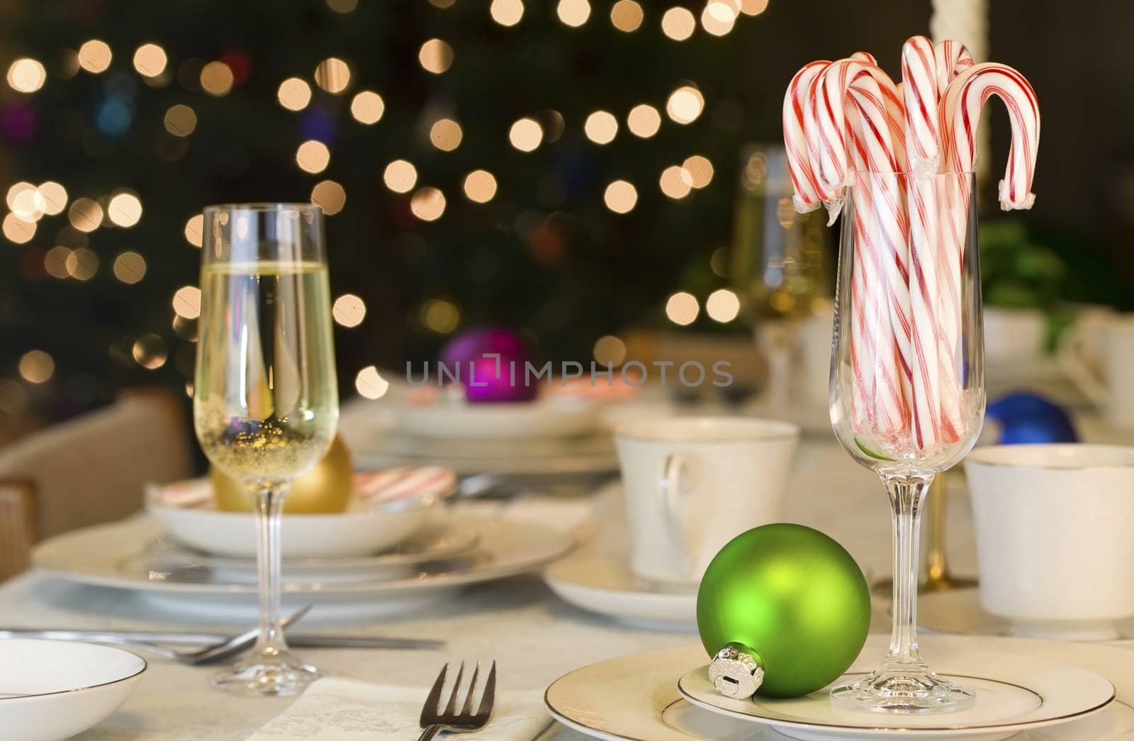 Candy canes and Christmas ornaments on dining table by jarenwicklund