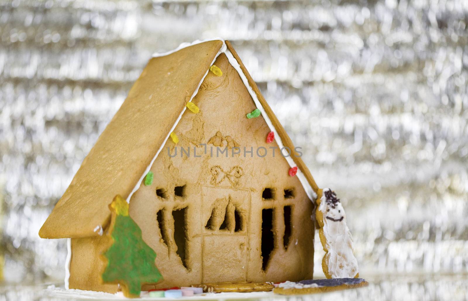Cute gingerbread house with silver shiny background by jarenwicklund