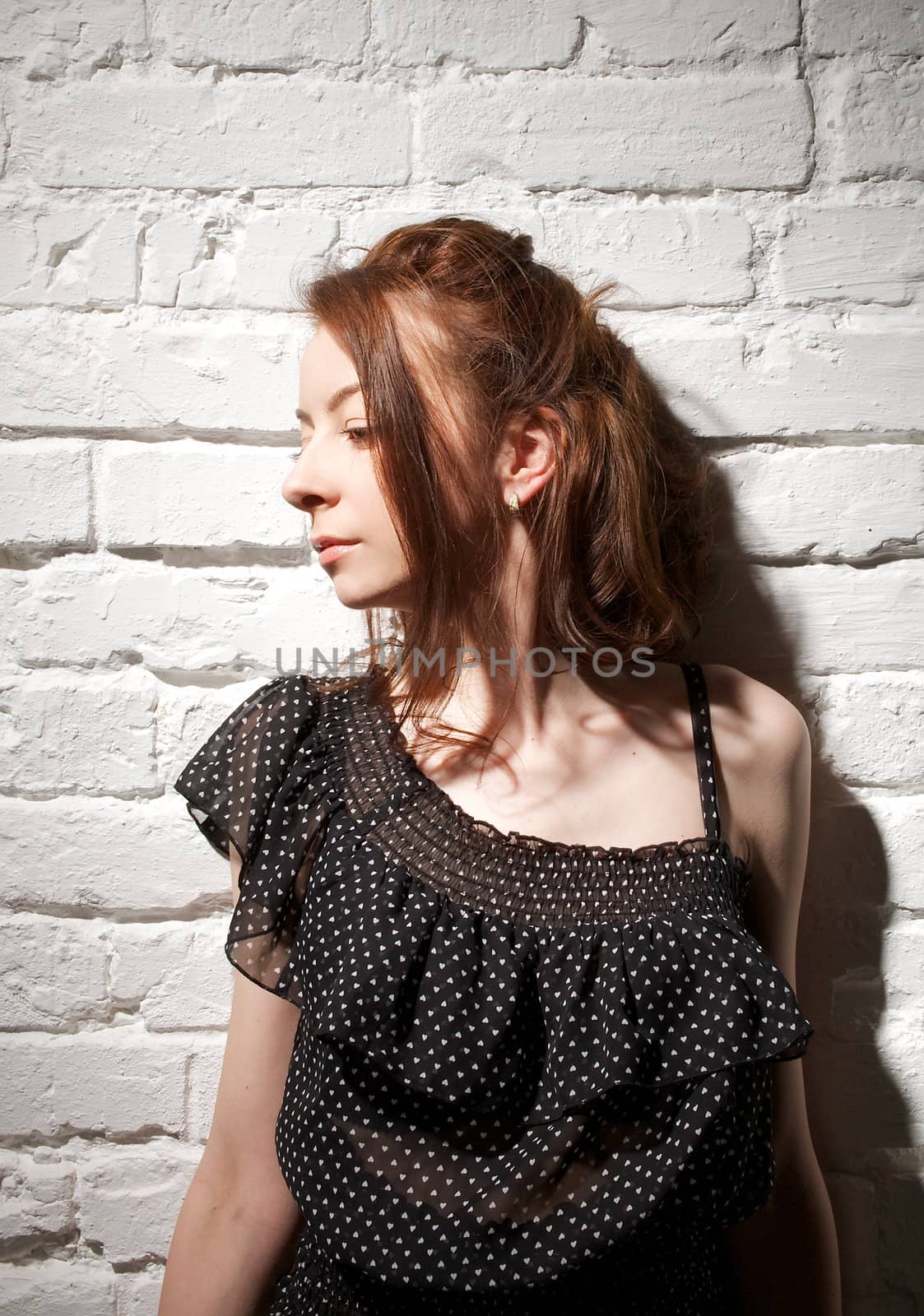 Portrait of Young Woman Looking Away on white brick background