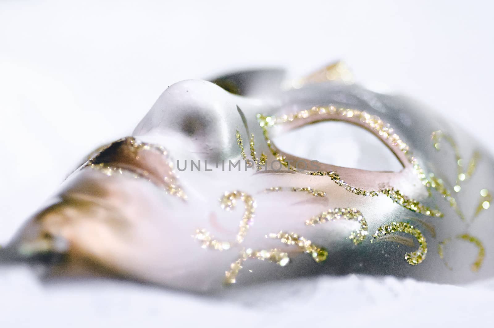 White theatrical mask with gold accents on a white background