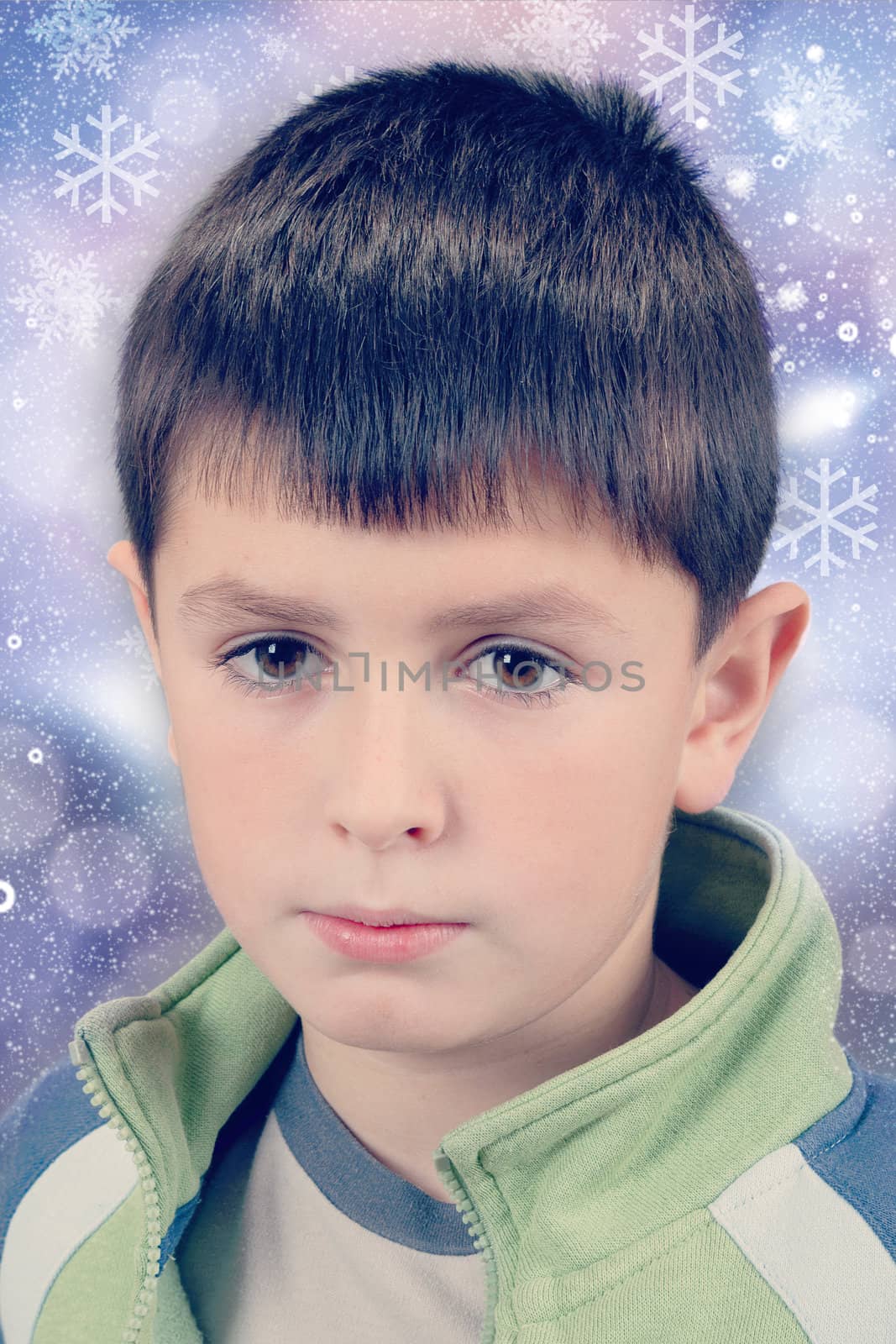 studio portrait of young boy on christmas background with snowflakes