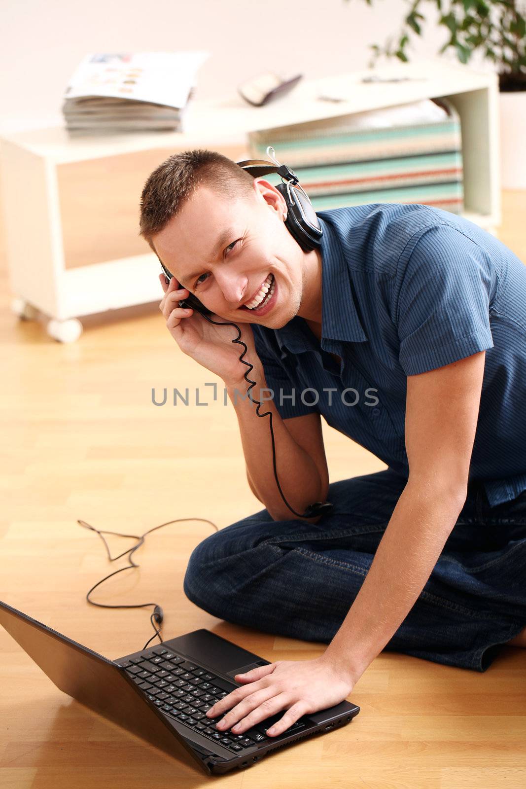 Young man listening music from laptop at home