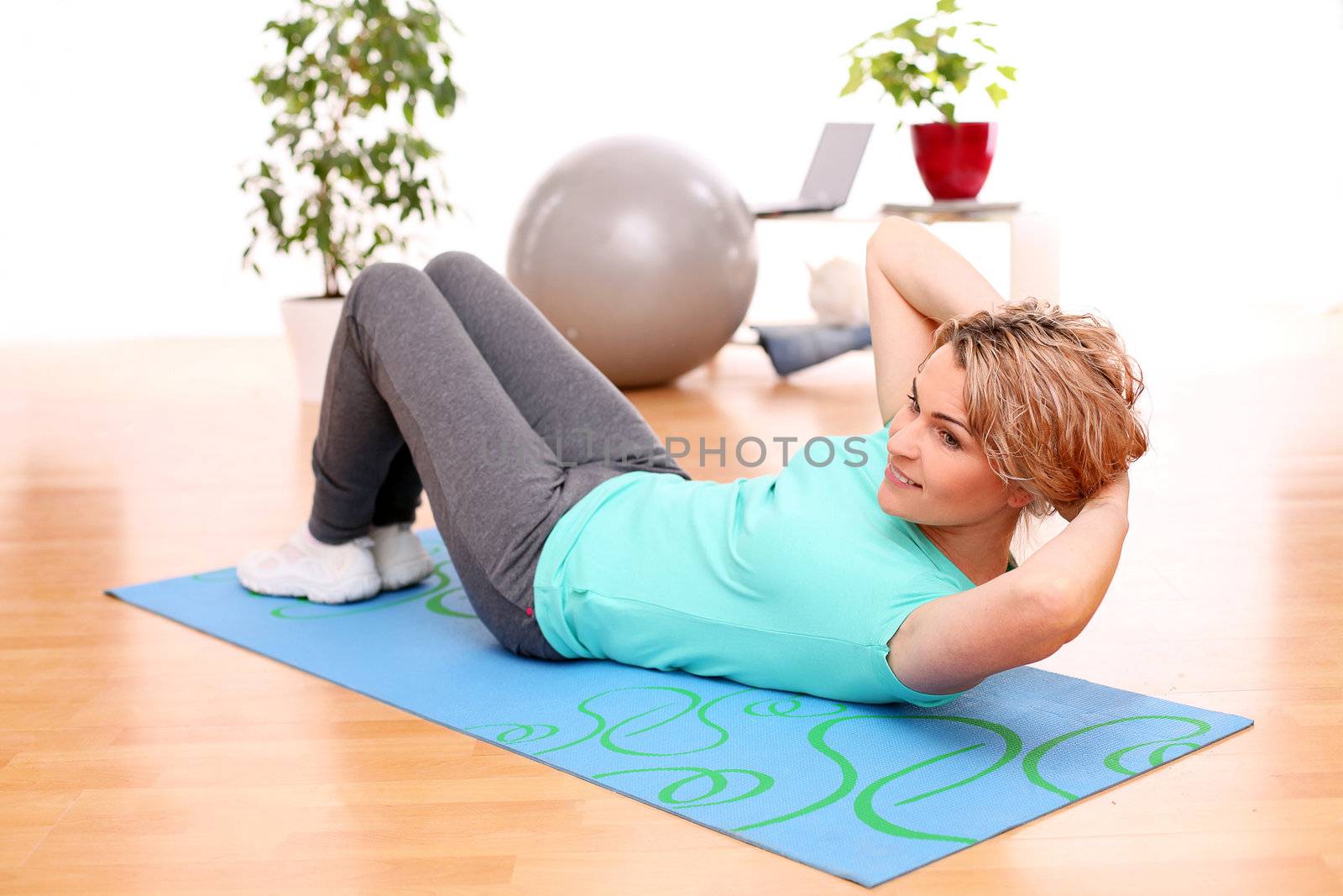 slim mid aged woman do her fitness exercises at home