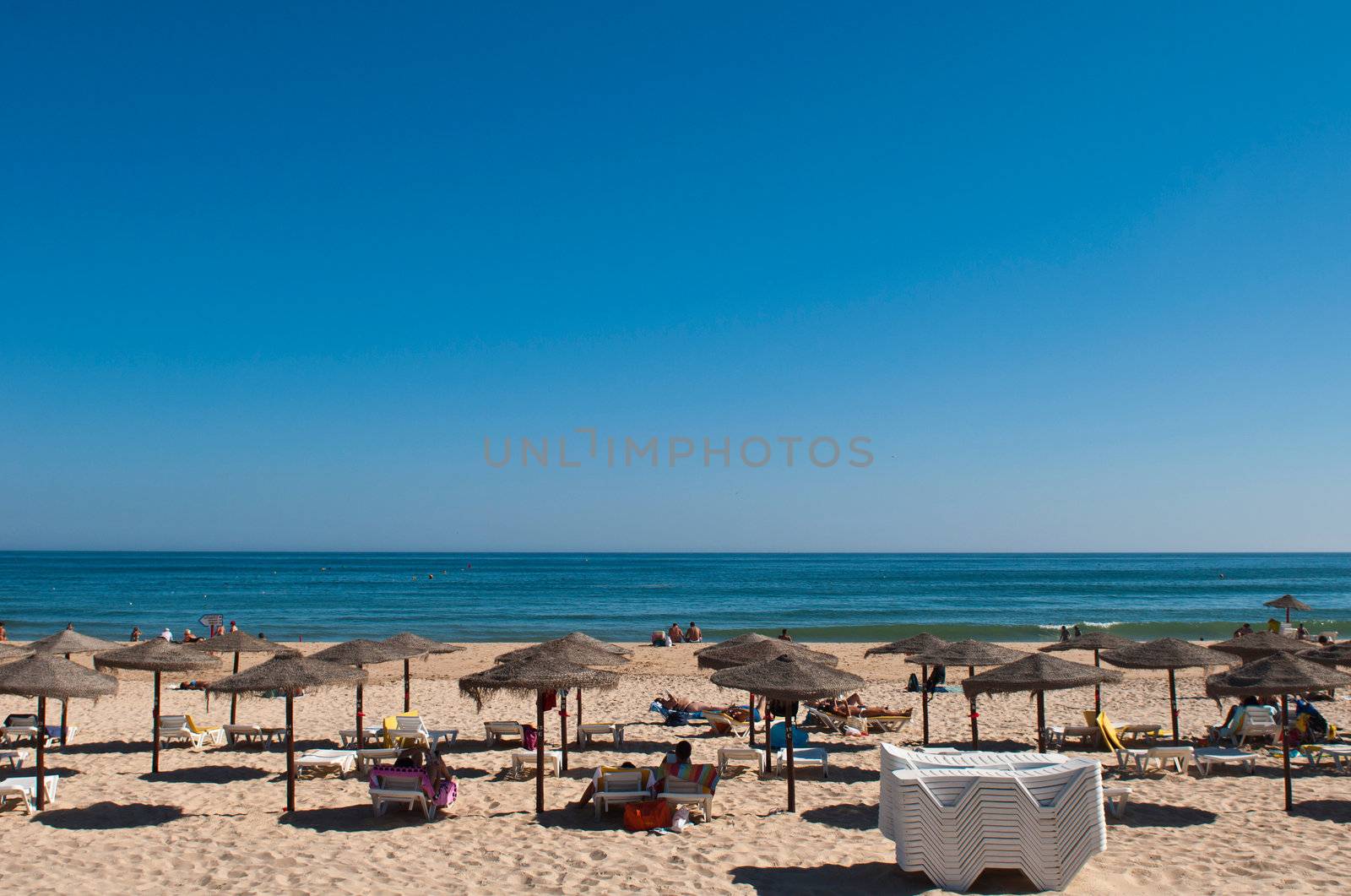 beautiful sandy beach with coconut parasols in Manta Rota (Algarve), Portugal