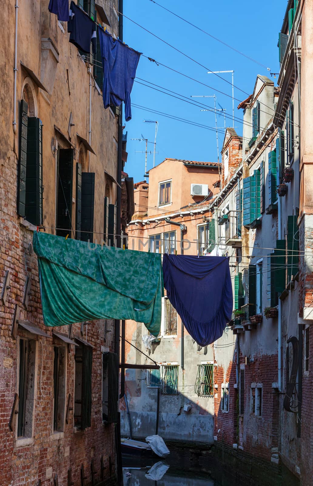 Clothes hanging out to dry between the buildings over a small canal in Venice,Italy.