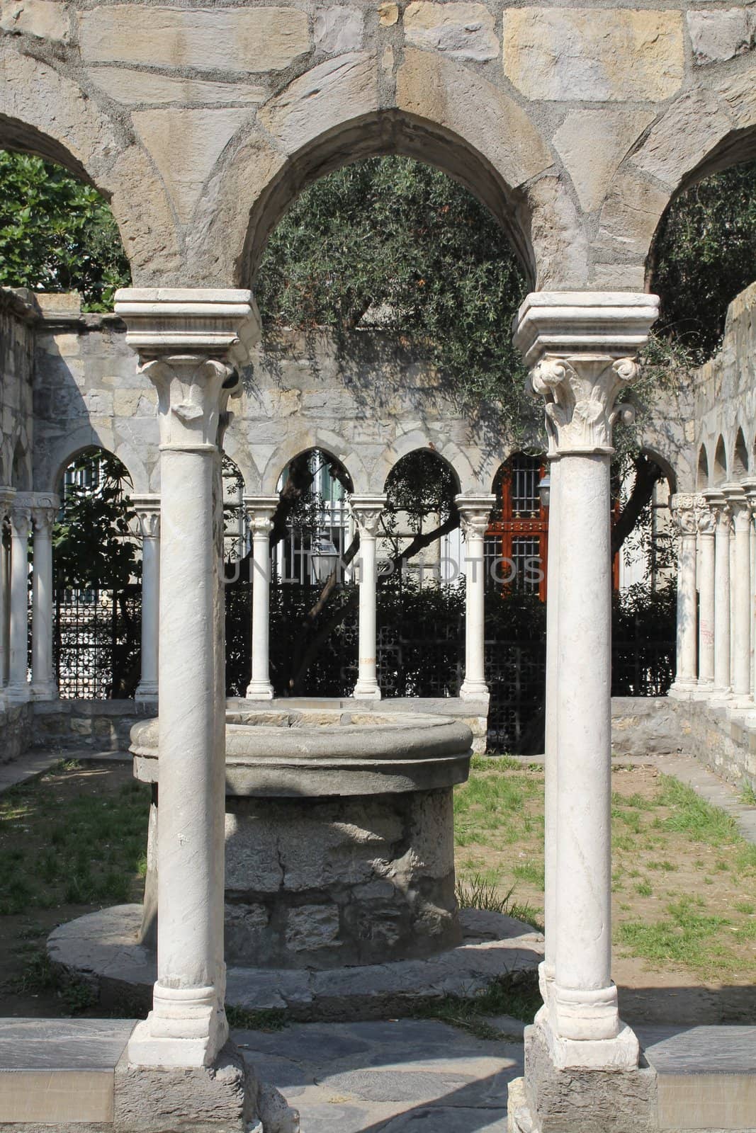 Cloister or courtyard of 12th century church with well in Genoa, Italy. 
