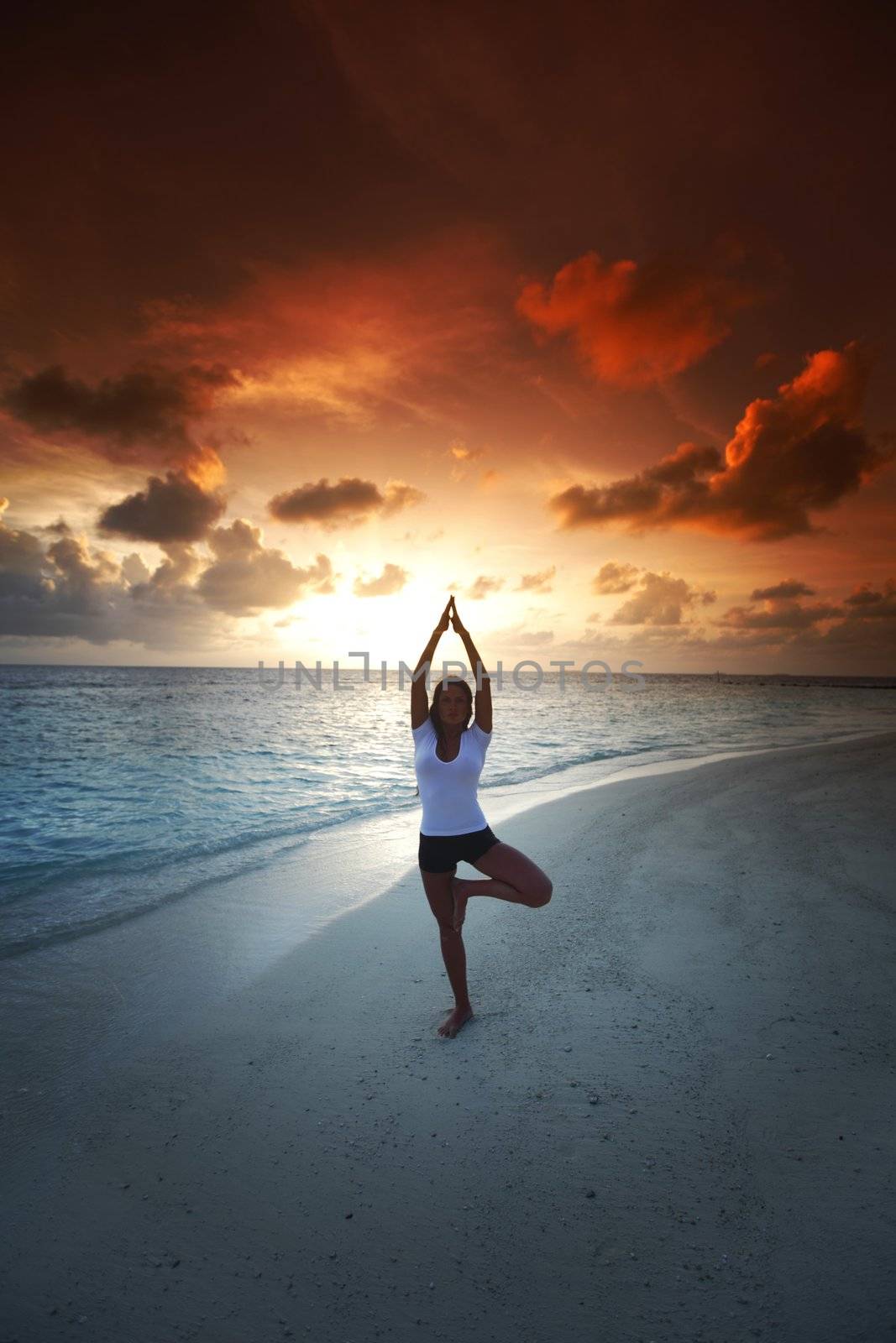 Yoga woman on beach at sunset by Yellowj