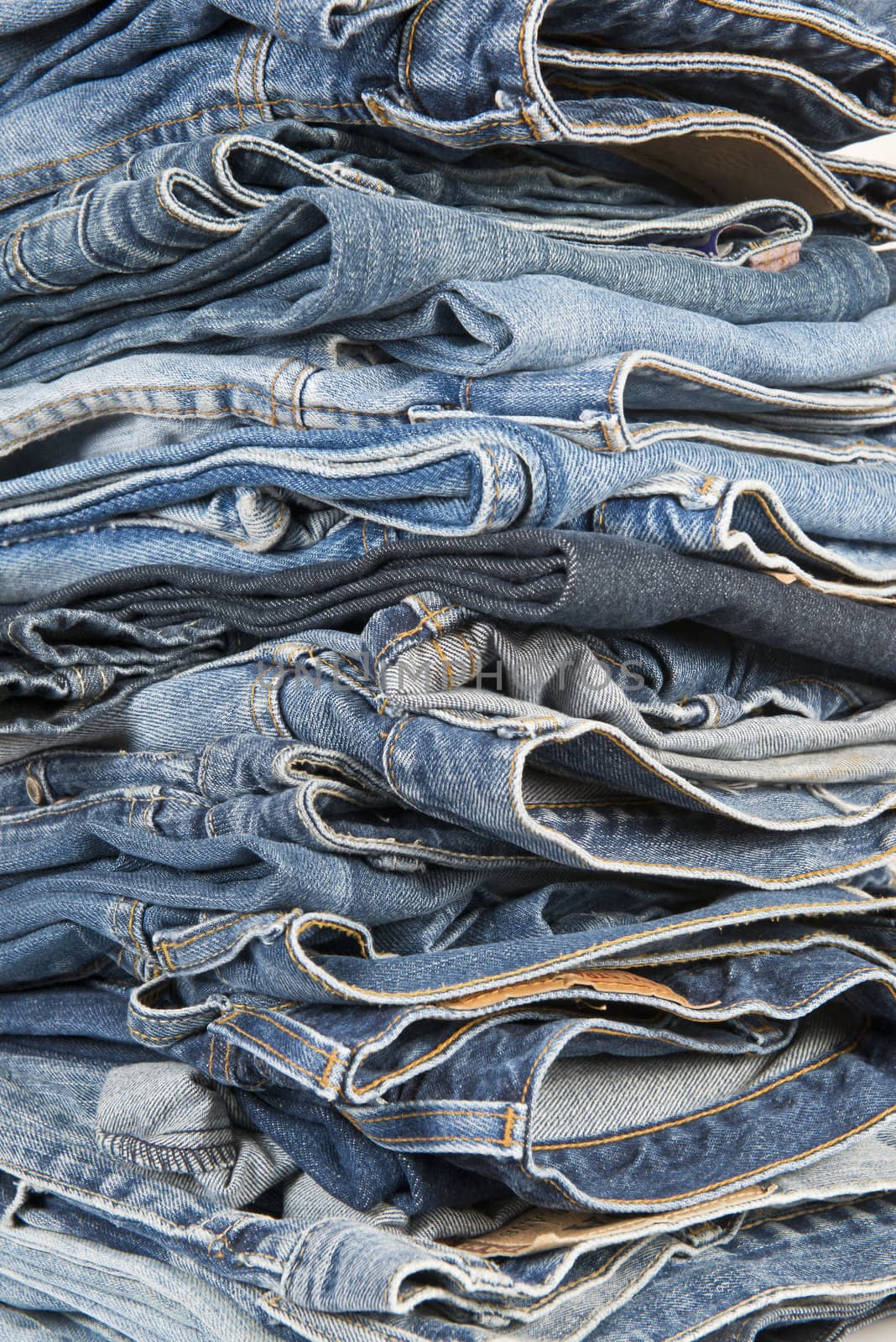 Closeup fron a stack of worn and old different  blue jeans