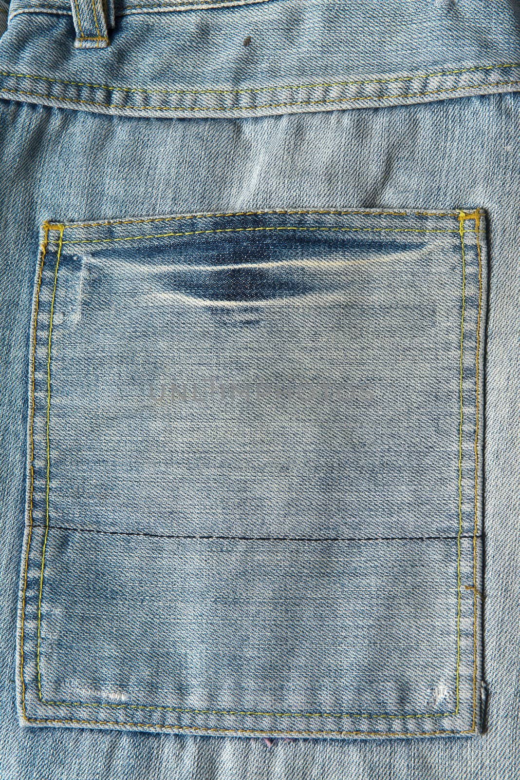 Closeup from the pocket of an old and worn blue jeans