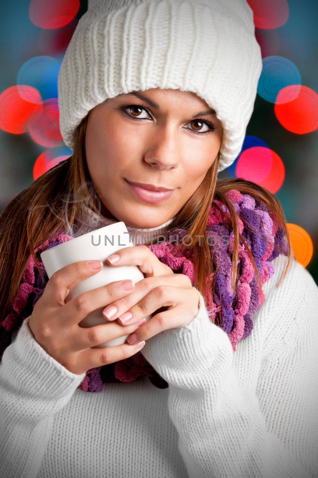 Young woman drinking a hot drink from a white mug