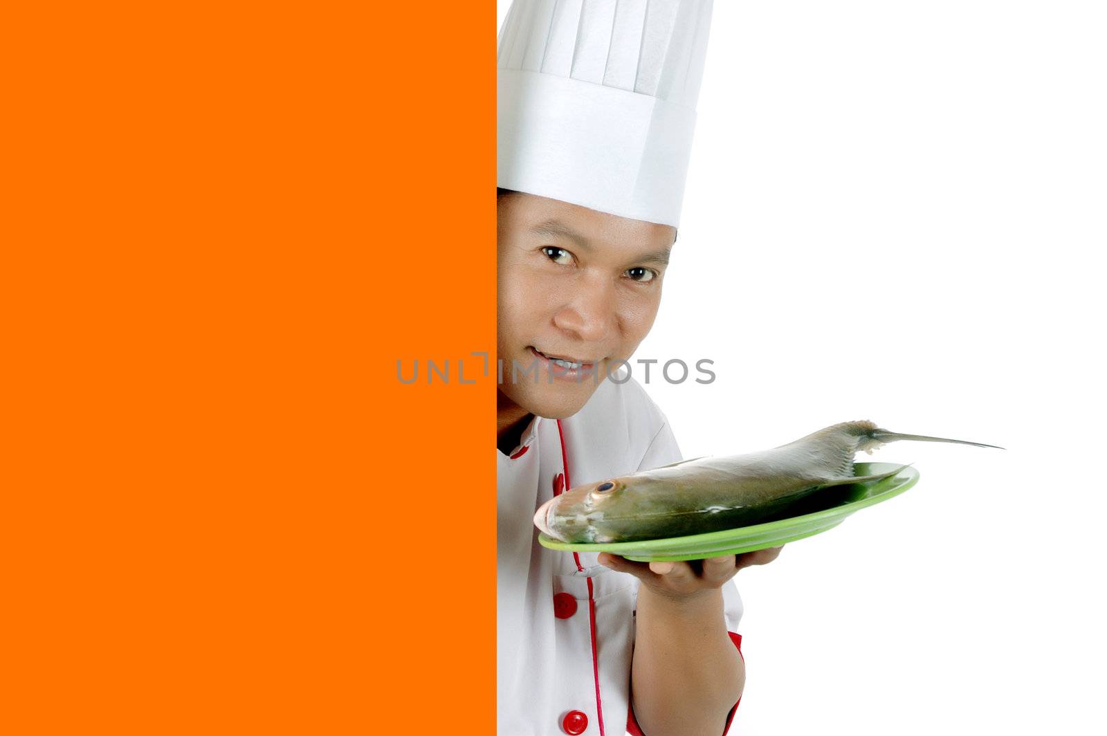 chef holding raw fish on a green plate with orange blank space isolated on white background