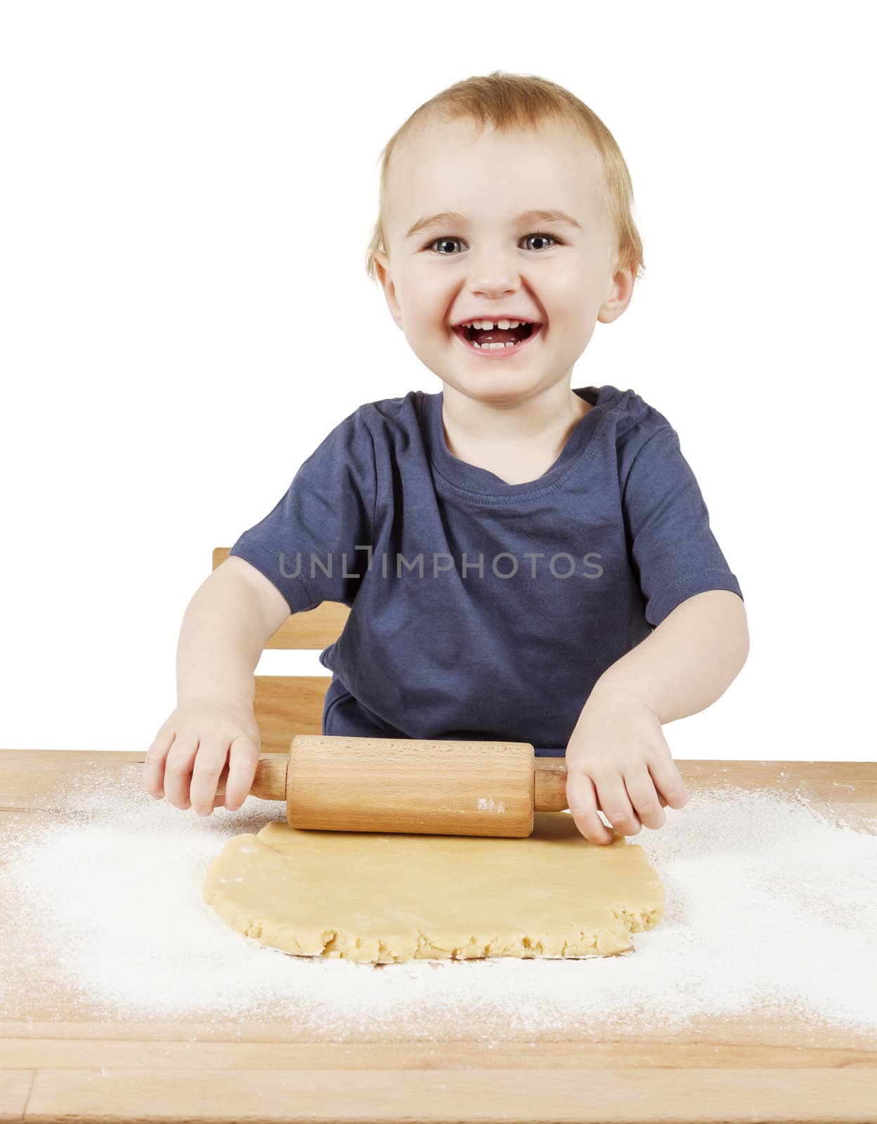 young child making cookies on small wooden desk