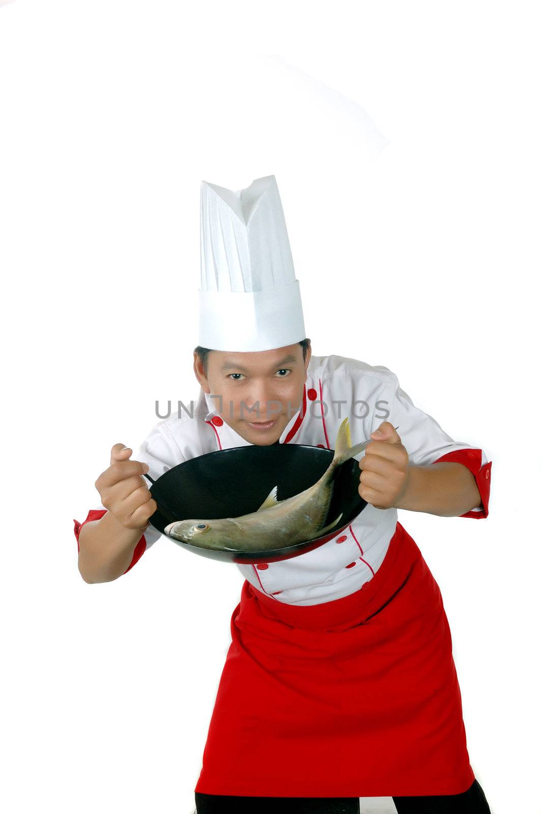 chef holding raw fish on a black frying pan isolated on white background