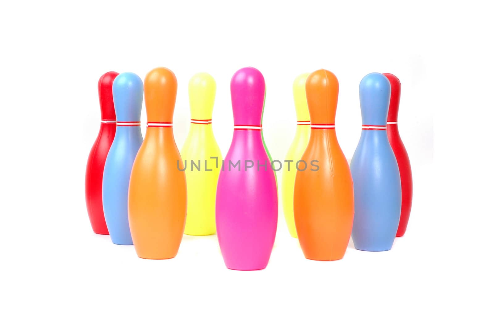 Row of colorful toy plastic bowling pins by antonihalim