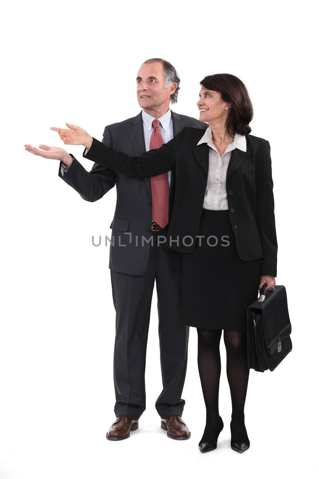 Mature businesscouple gesturing at blank copyspace