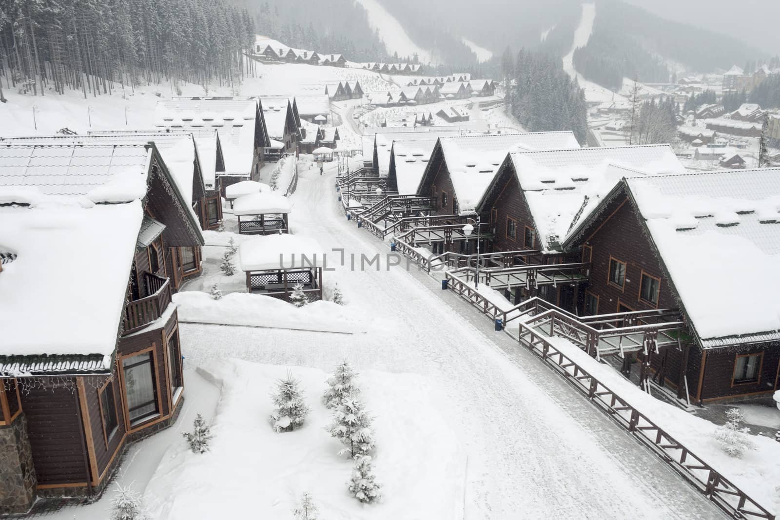 winter street in alpine village under snowfall