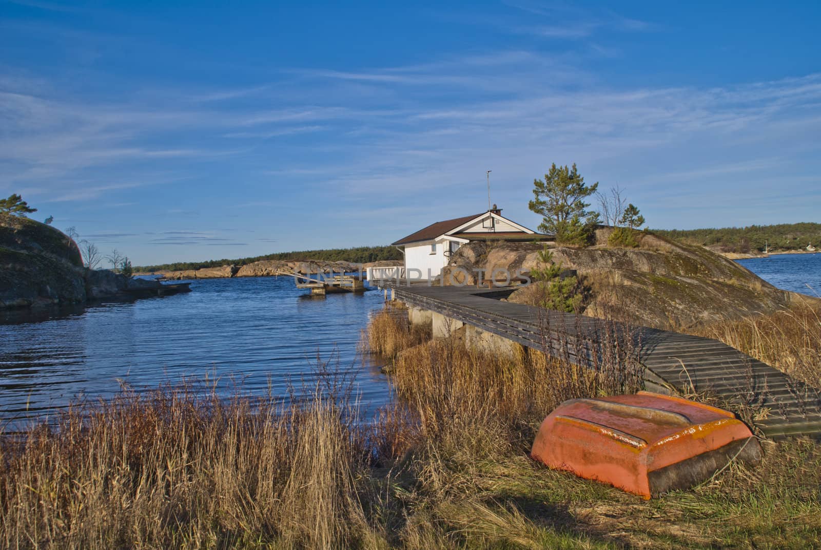 the cottage is built on a rock out at sea with its own pier promenade the cabin is beautifully situated near svalerødkilen in halden, image is shot in november 2012.