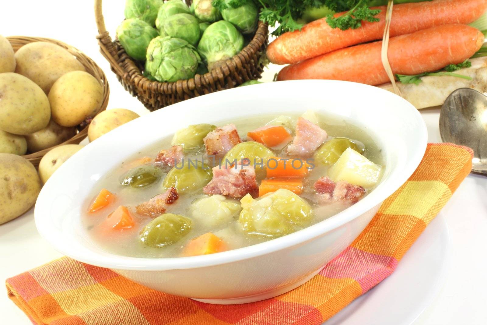 cooked Brussels sprouts soup with potatoes, leeks, carrots, celery and bacon