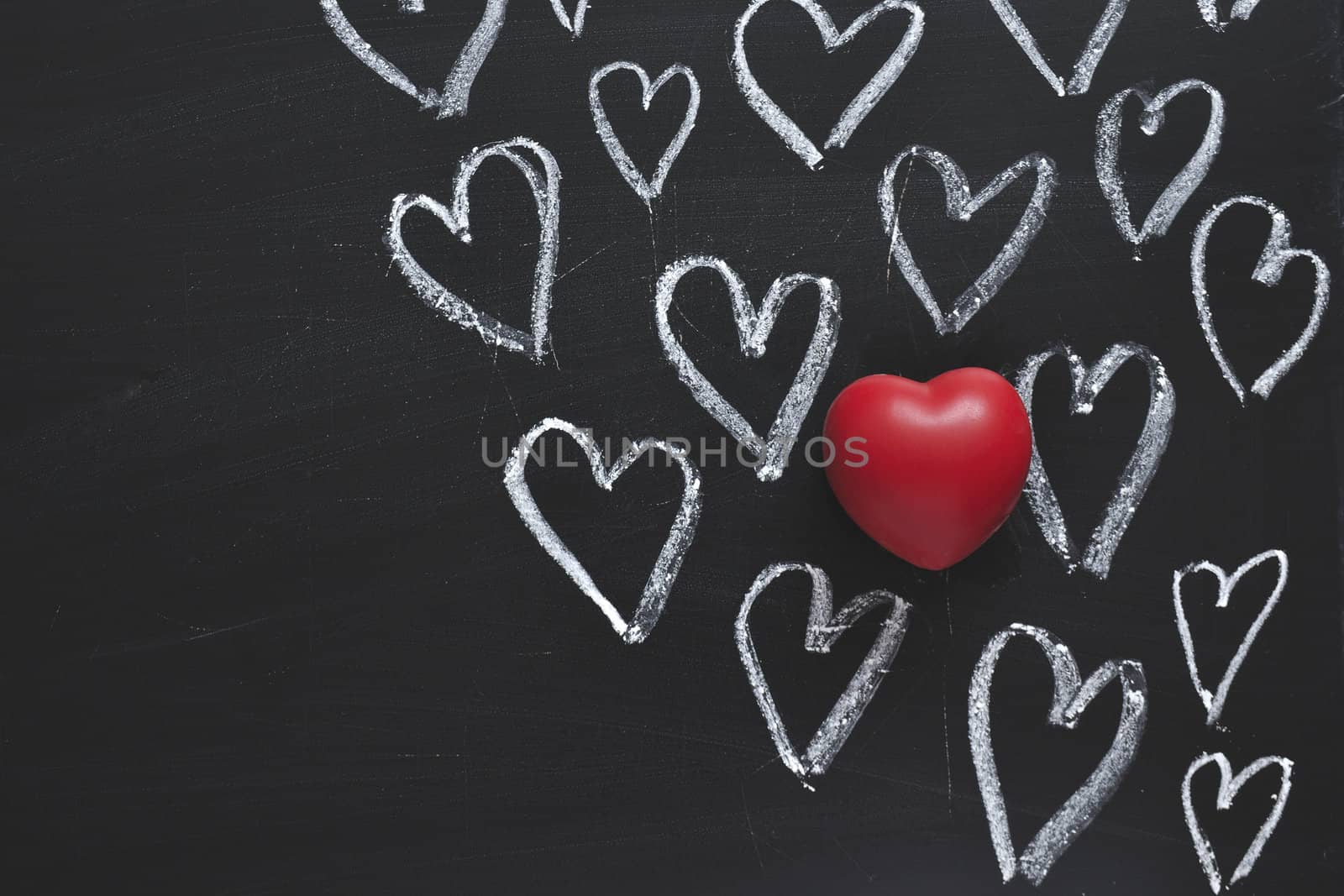 hand-drawn hearts symbols on the blackboard with red one over them
