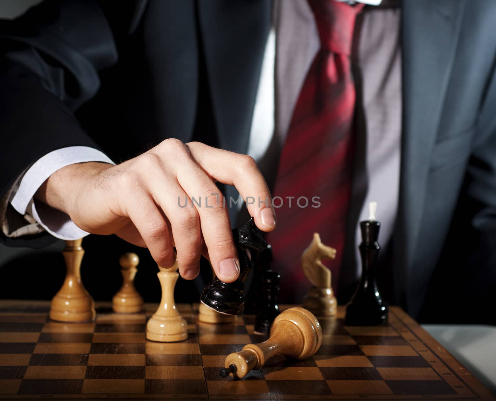 image of the businessman in a business suit plays chess