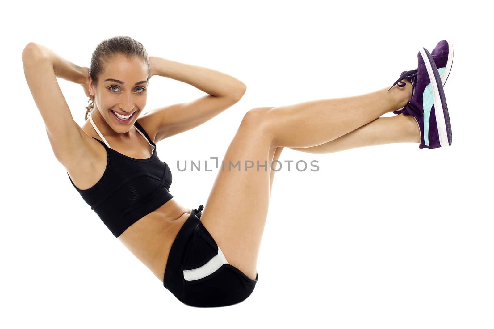 Fit woman in sporty attire doing crunches by stockyimages