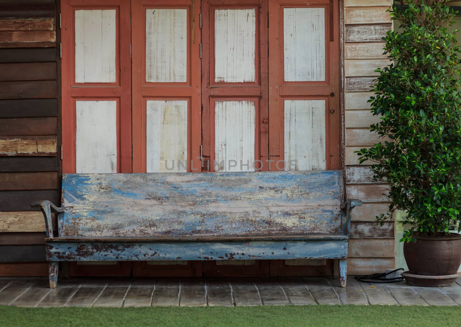 Old chair with the background of old wooden house.