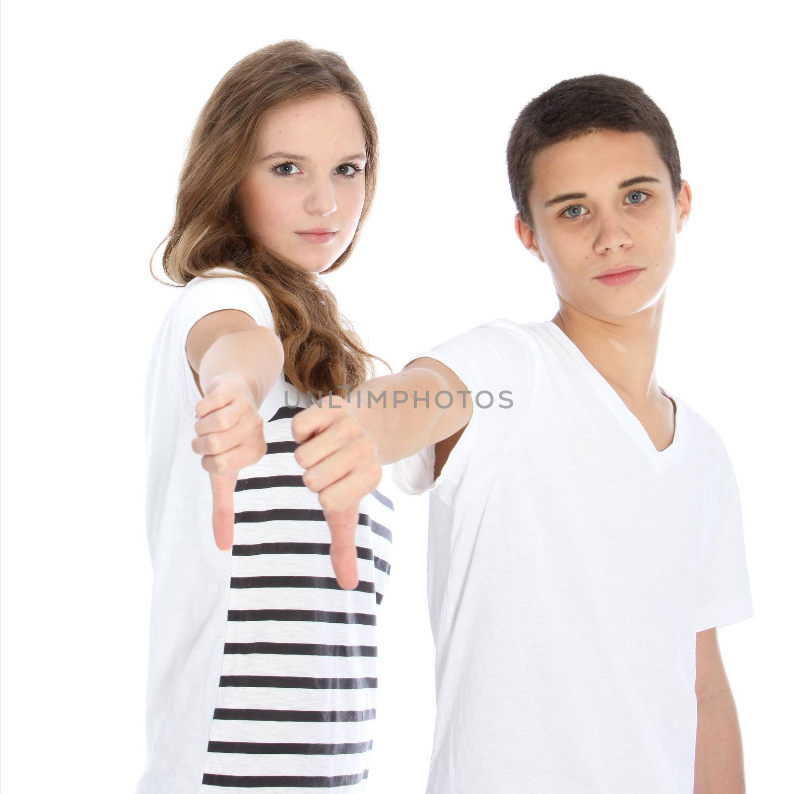 Unimpressed teenagers giving a thumbs down gesture of condemnation and refusal isolated on white