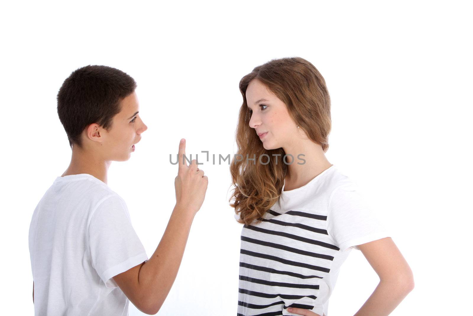 Two young teenagers arguing with the boy wagging his finger at his sister in a dogmatic manner, upper body studio portrait on white