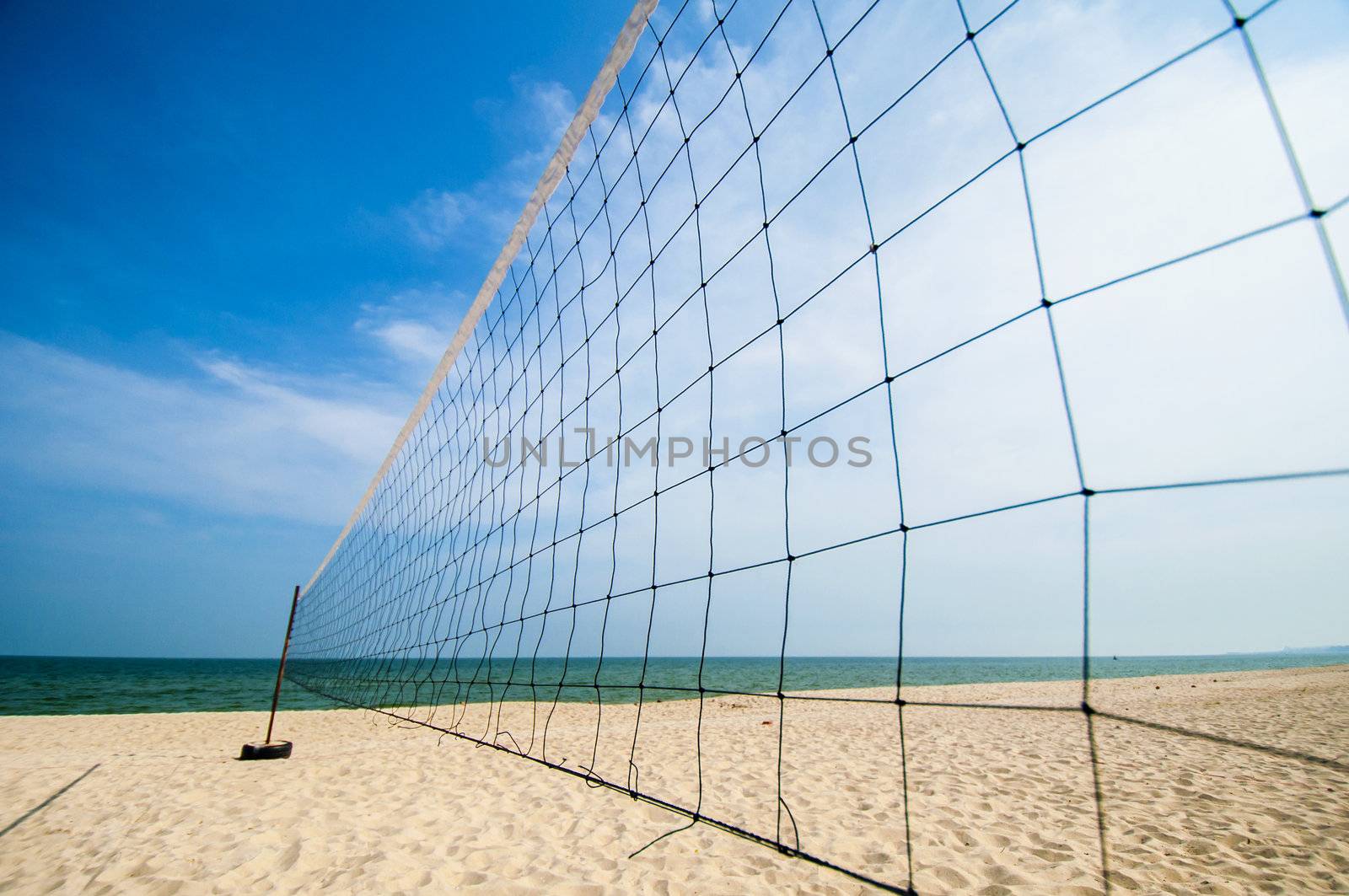 Torn beach volleyball net at tropical beach