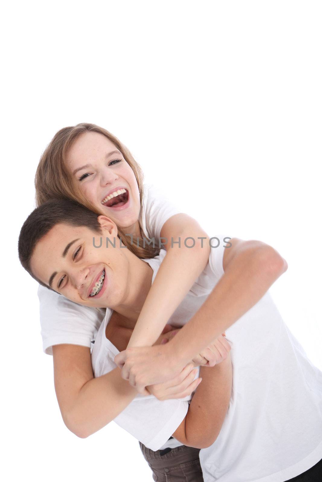 Laughing teenage brother and sister having fun together fooling around mock wrestling isolated on white