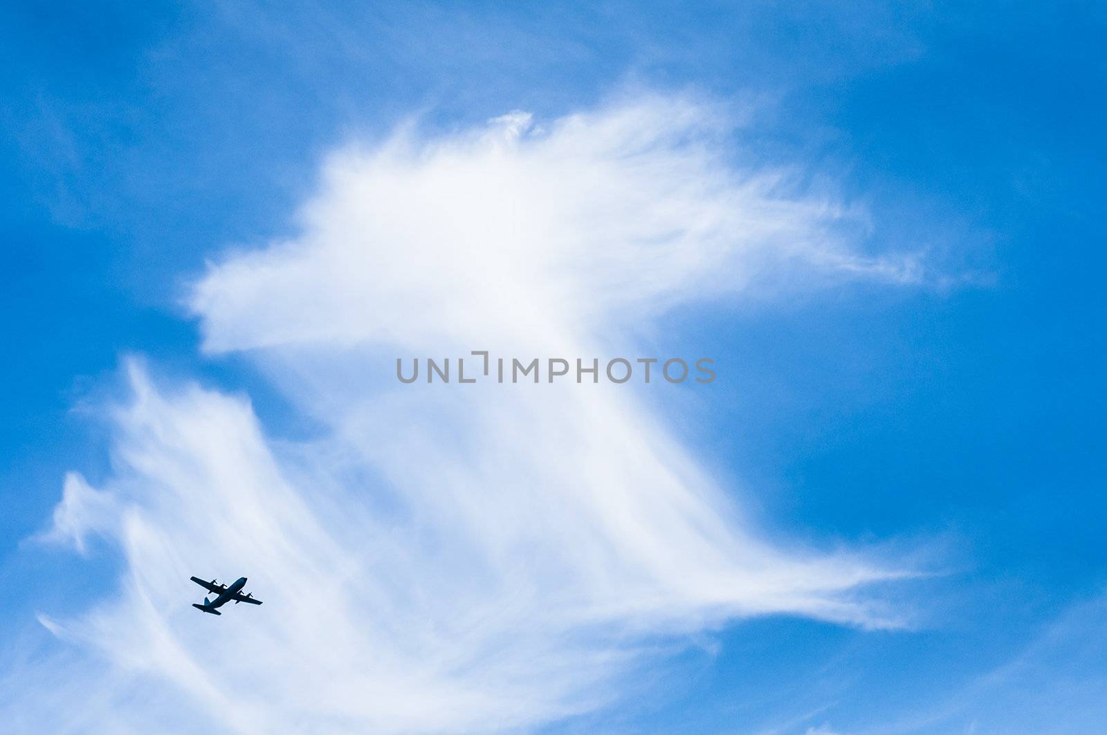 An airplane (aircraft)  flying in the blue sky