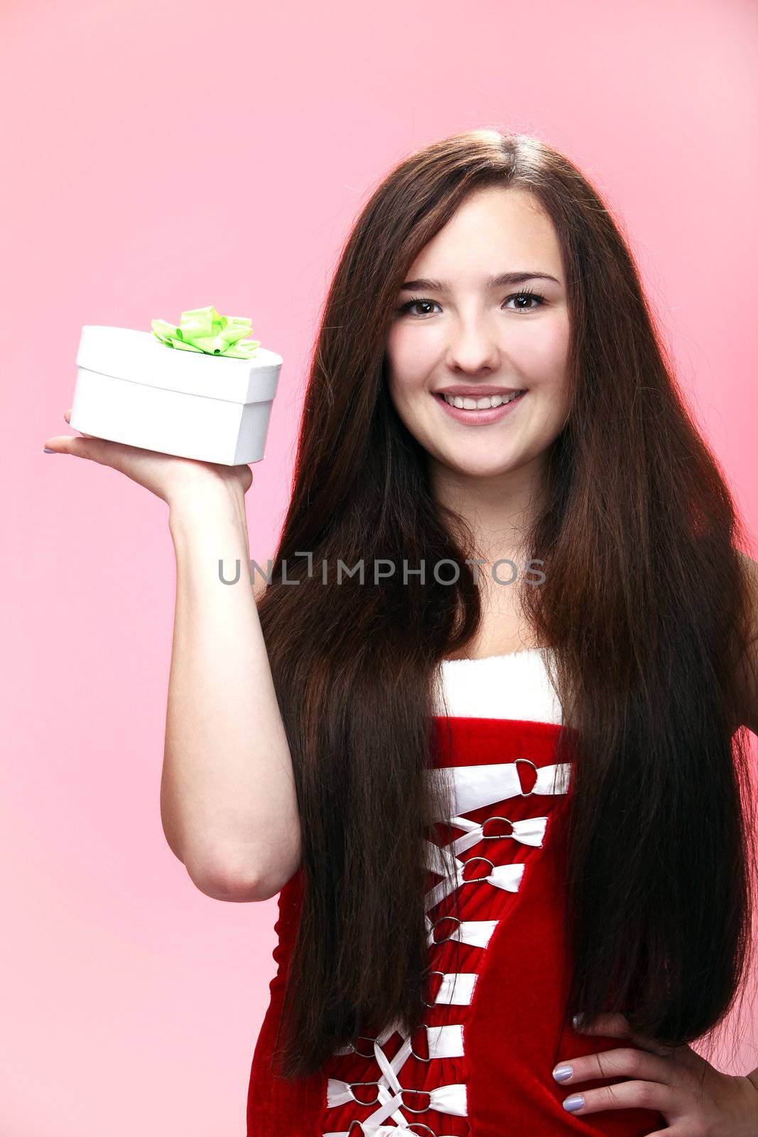 Portrait of young and beautiful christmas girl in red with gift